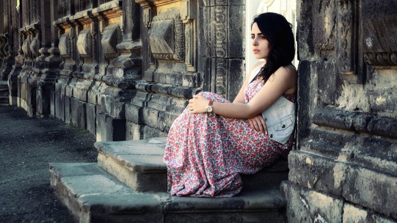 woman in floral dress sitting on steps