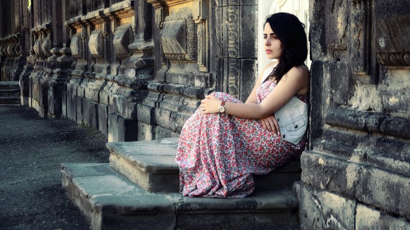 Woman in floral dress sitting on steps
