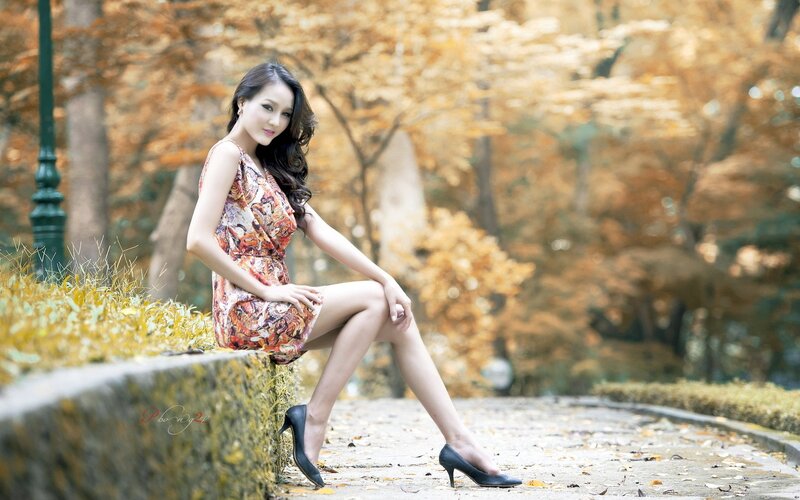Woman in floral dress sitting outdoors