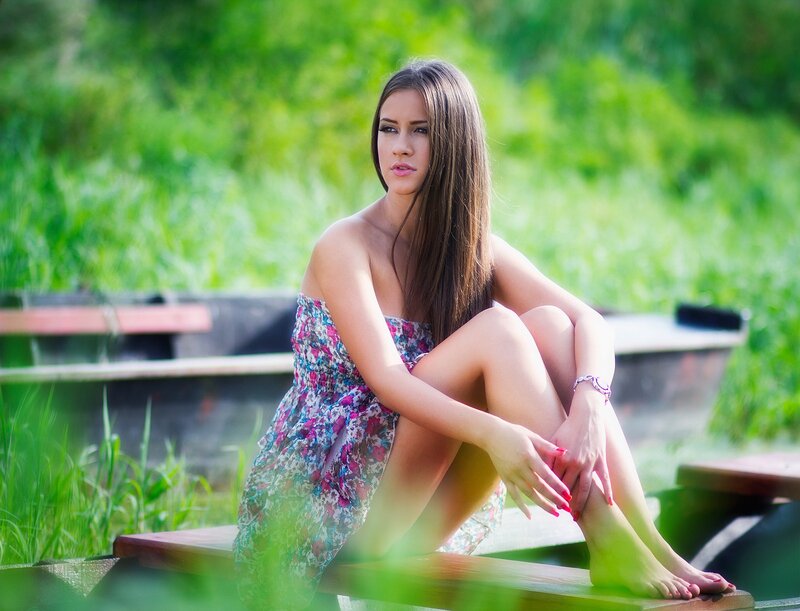 Woman in floral dress sitting outdoors