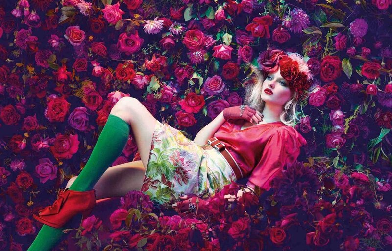 woman in floral dress surrounded by roses