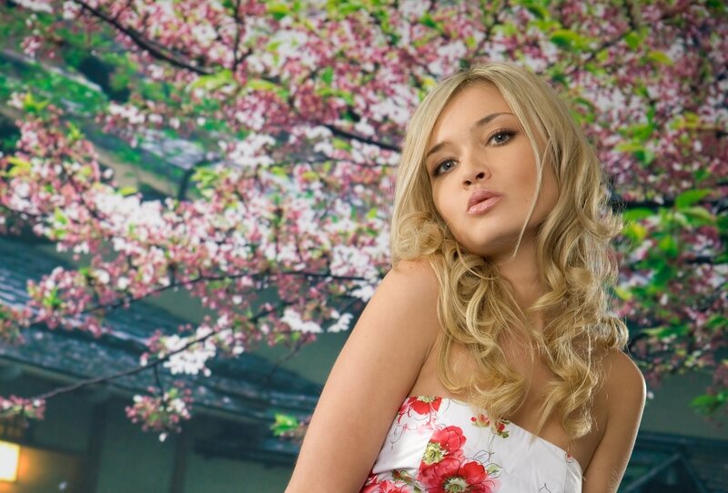 woman in floral dress under cherry blossoms