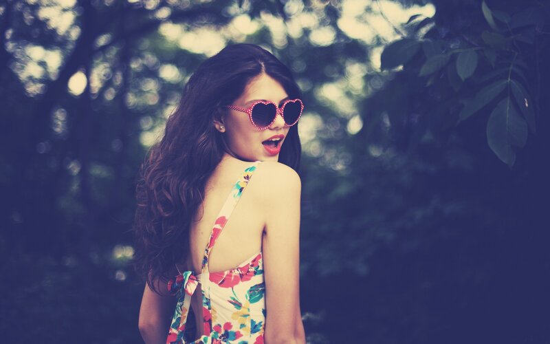 woman in floral dress with heart sunglasses