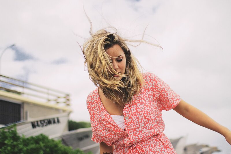 woman in floral dress with wind-blown hair