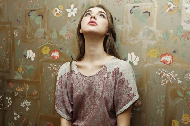 woman in floral room looking up