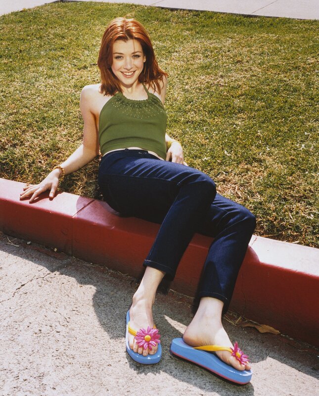 Woman in floral sandals sitting on curb