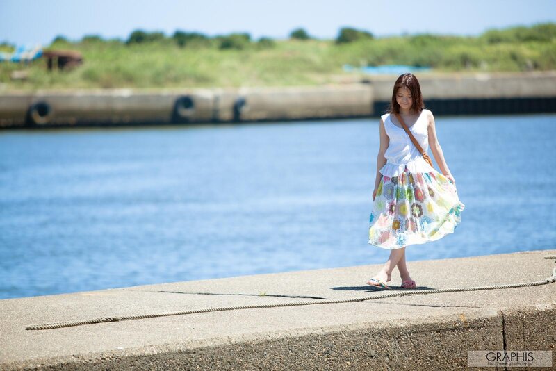 Woman in floral skirt by the water