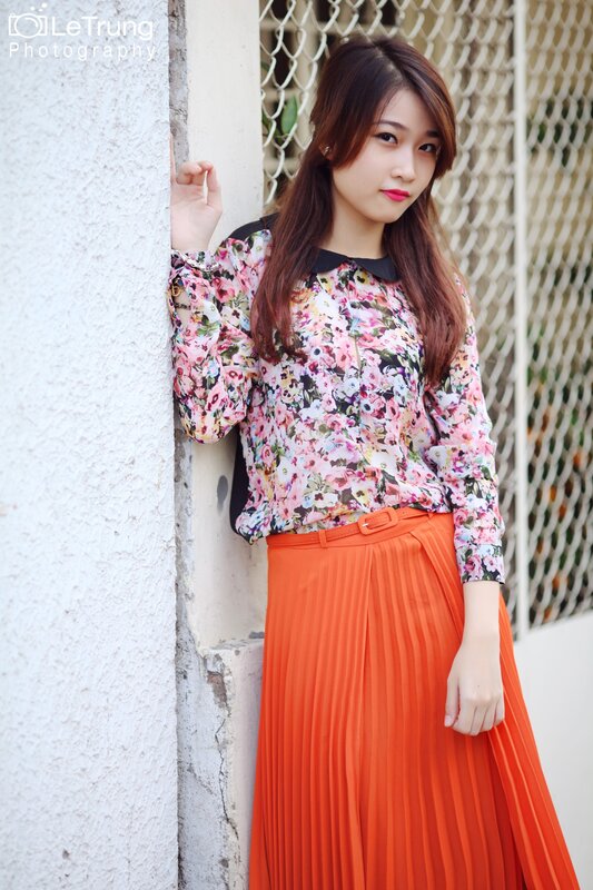 woman in floral top and orange skirt