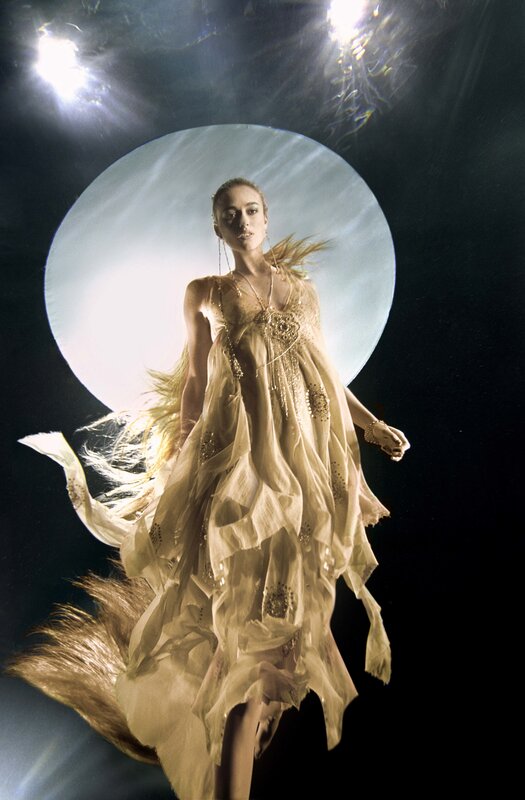 woman in flowing dress under spotlight