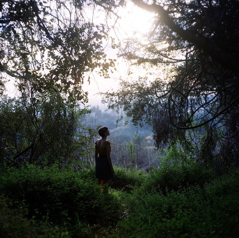Woman in forest at sunrise