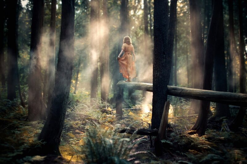 Woman in forest at sunrise