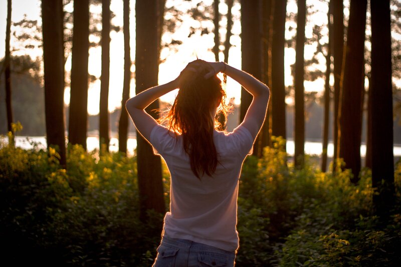 woman in forest at sunset