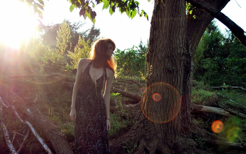 Woman in forest at sunset
