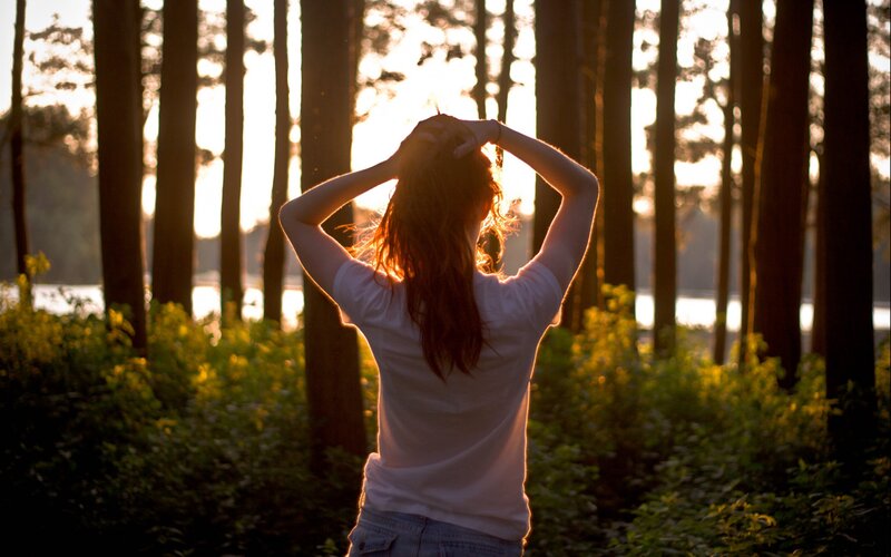 woman in forest at sunset