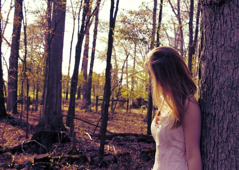 Woman in forest at sunset