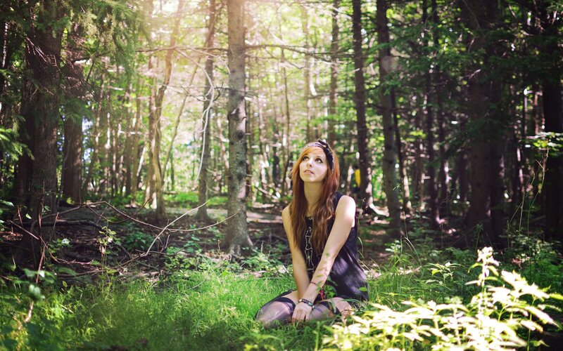 Woman in forest at sunset