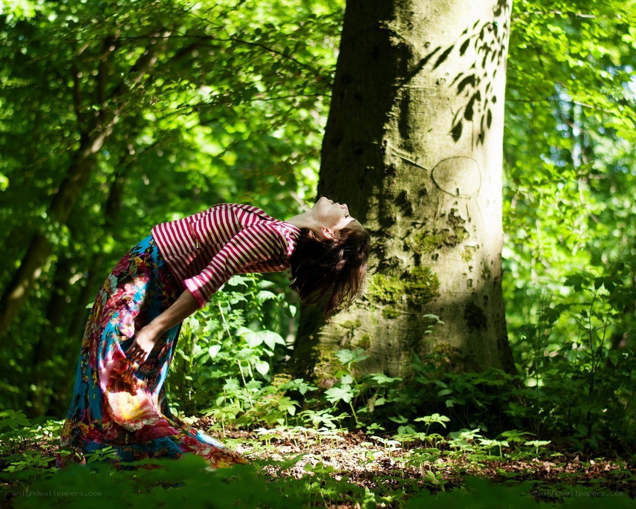 Woman in forest bending backward