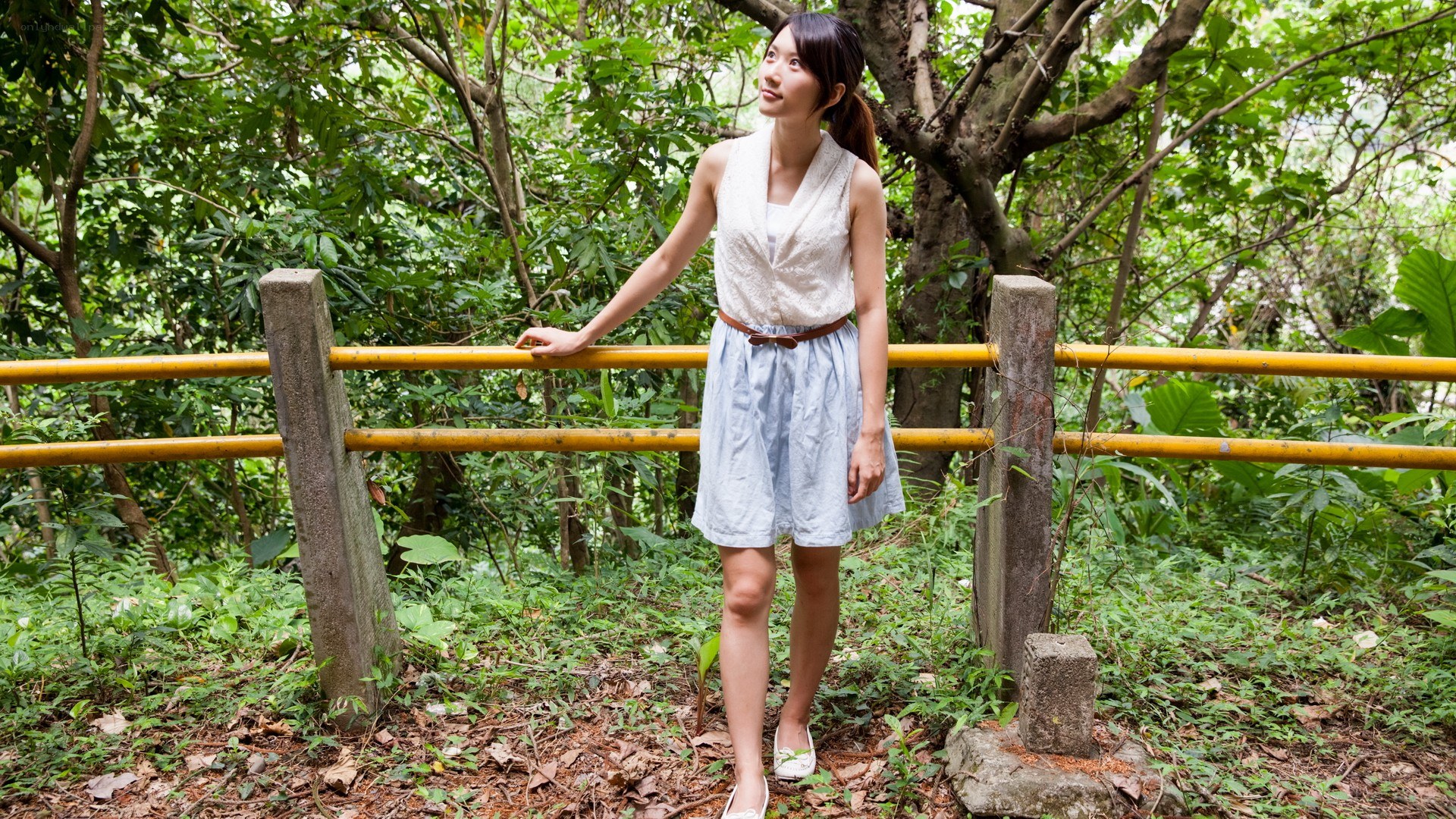 Woman in forest by railing