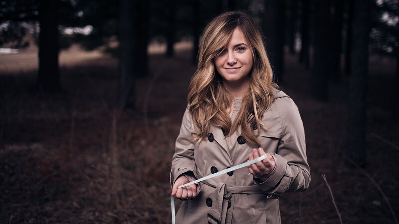 woman in forest holding ribbon