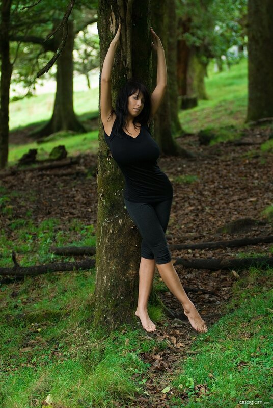 Woman in forest leaning on tree