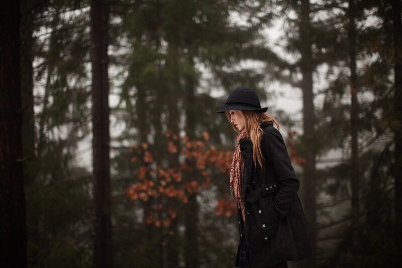 woman in forest wearing hat