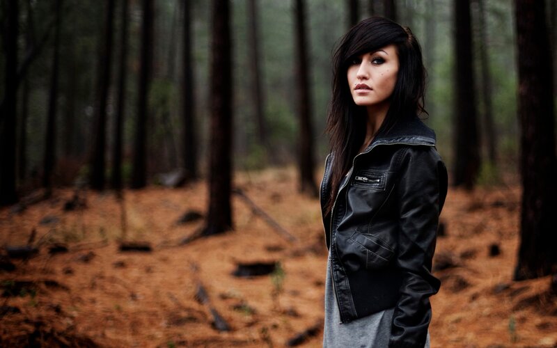 woman in forest wearing leather jacket
