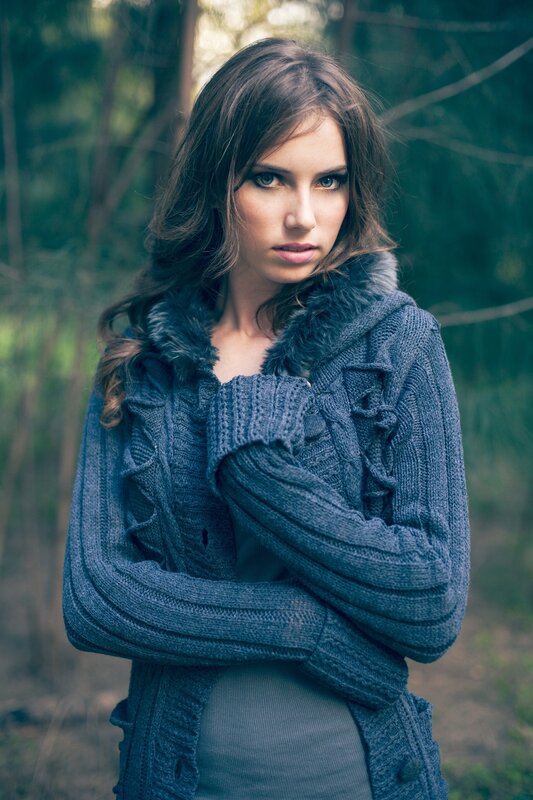 woman in forest wearing sweater
