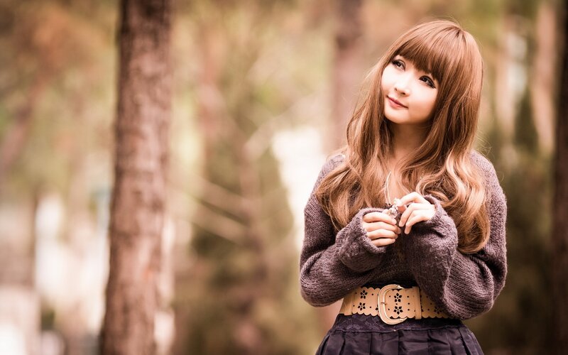 woman in forest wearing sweater
