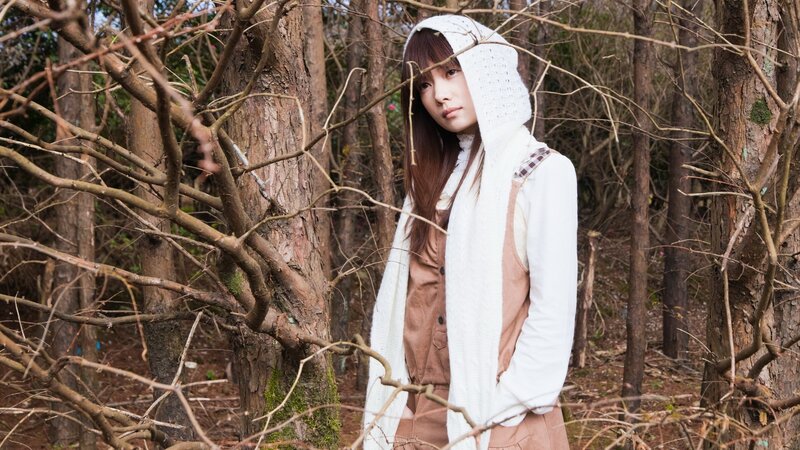 woman in forest wearing white hoodie