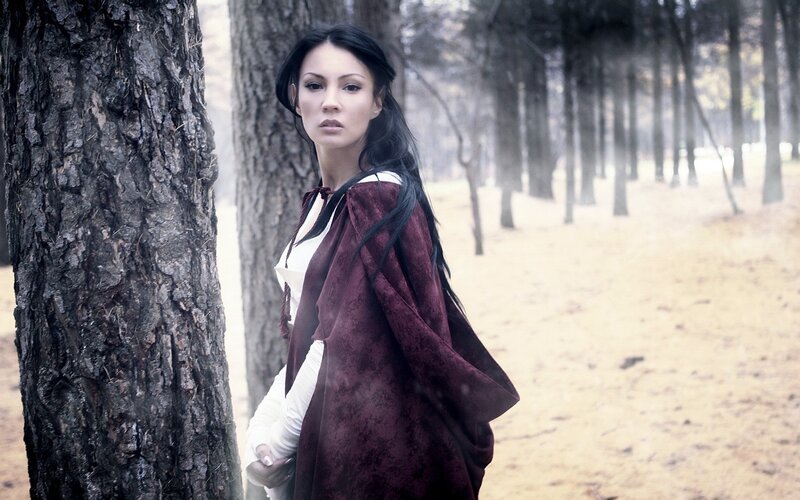woman in forest with cloak