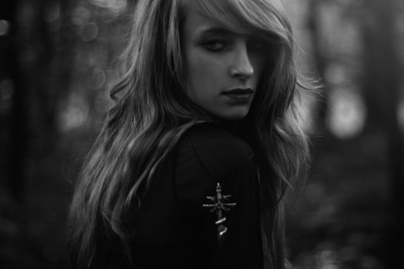 woman in forest with cross pin