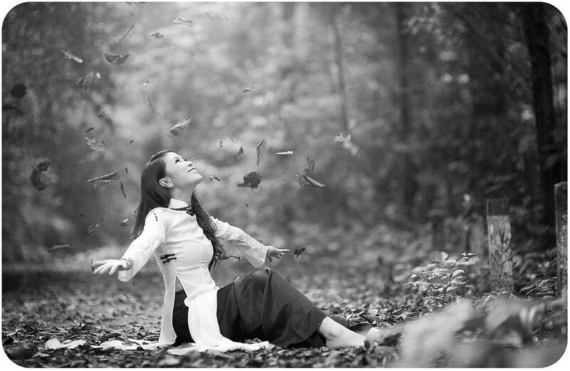 Woman in forest with falling leaves