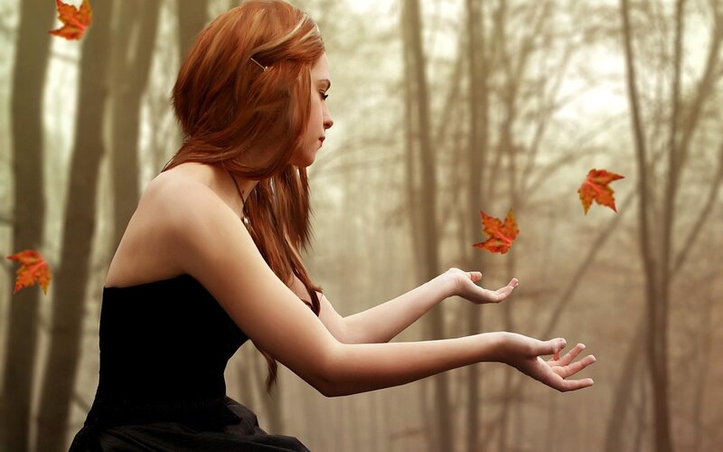 woman in forest with falling leaves