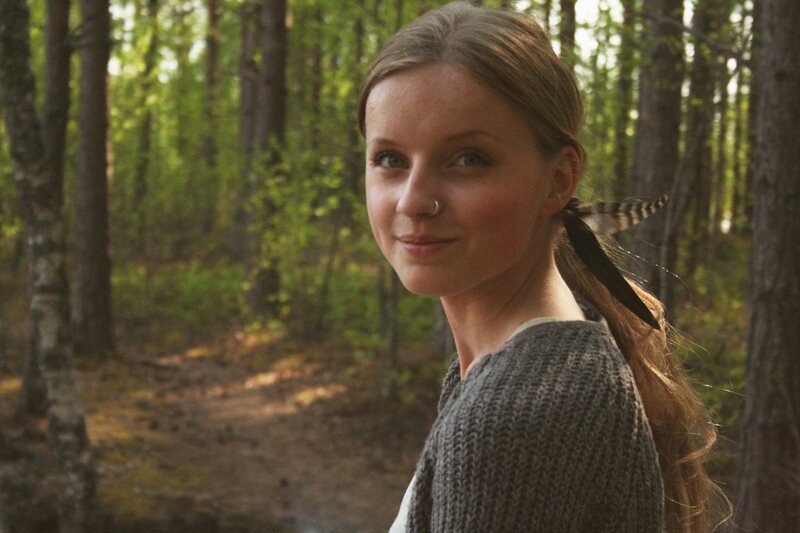 woman in forest with feather