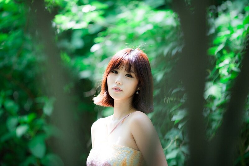 woman in forest with green light