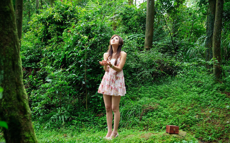 Woman in forest with hands raised