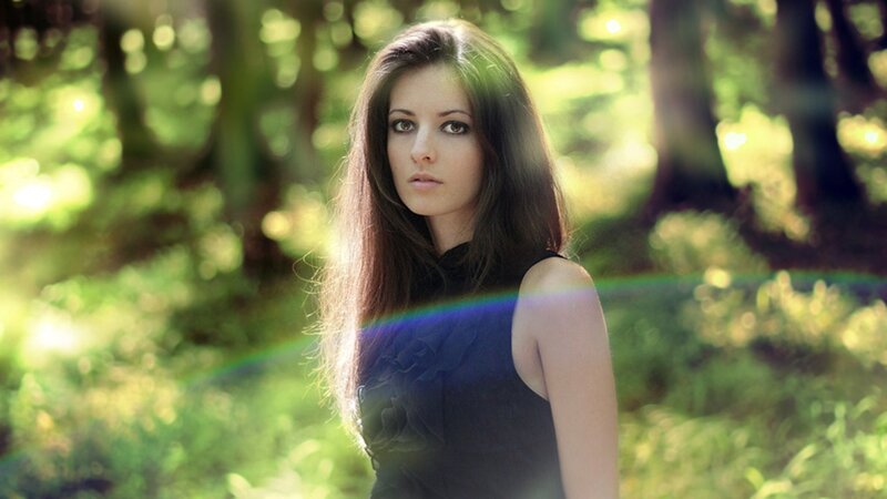 woman in forest with lens flare
