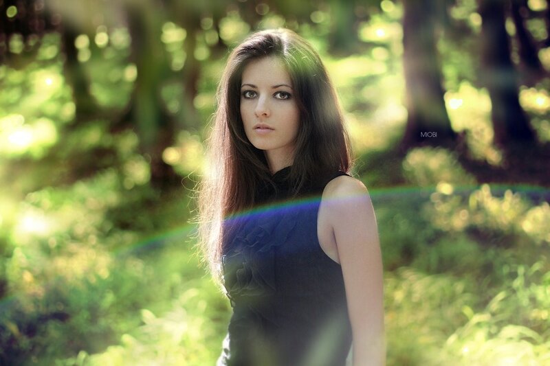 woman in forest with lens flare
