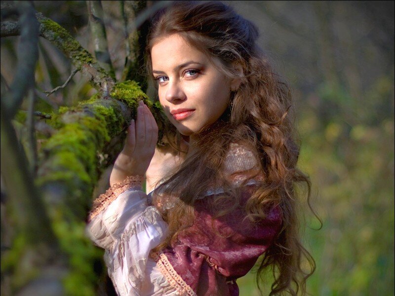 woman in forest with mossy tree