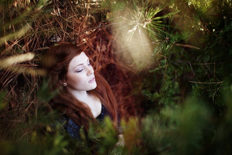 woman in forest with pine needles
