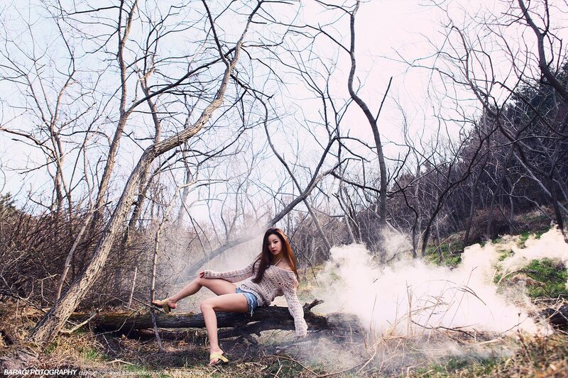 Woman in forest with smoke
