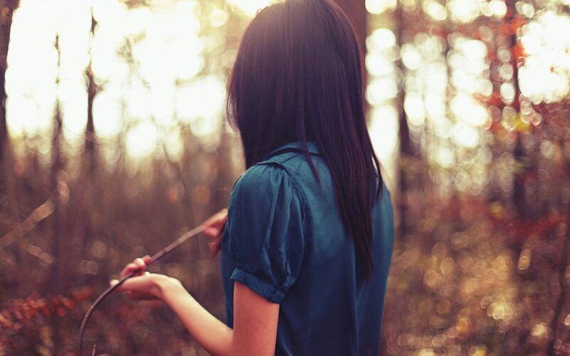 woman in forest with stick