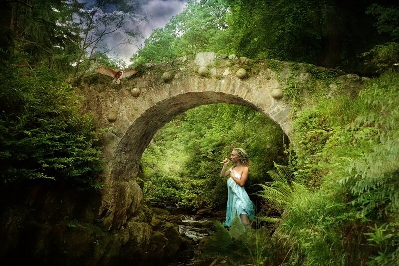 Woman in forest with stone bridge