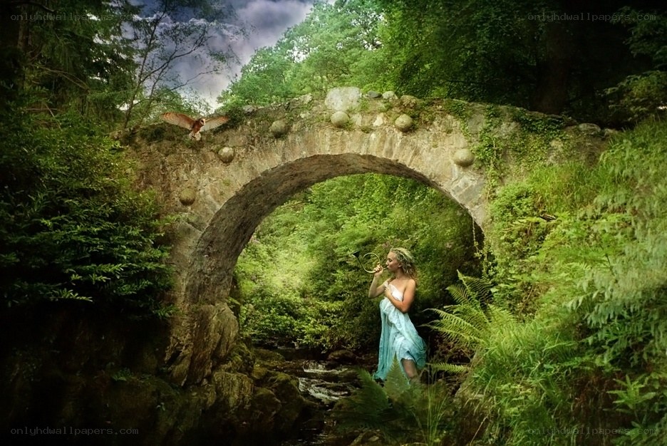 Woman in forest with stone bridge