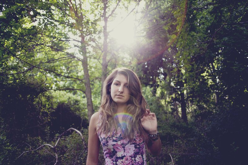 woman in forest with sun flare