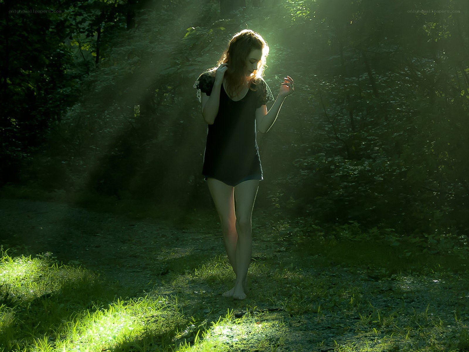 Woman in forest with sunbeams