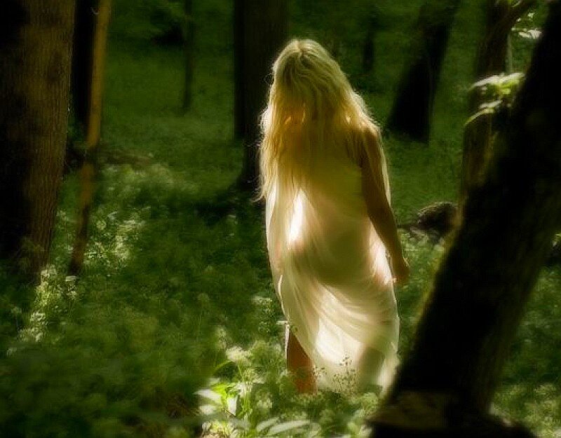 woman in forest with sunlight