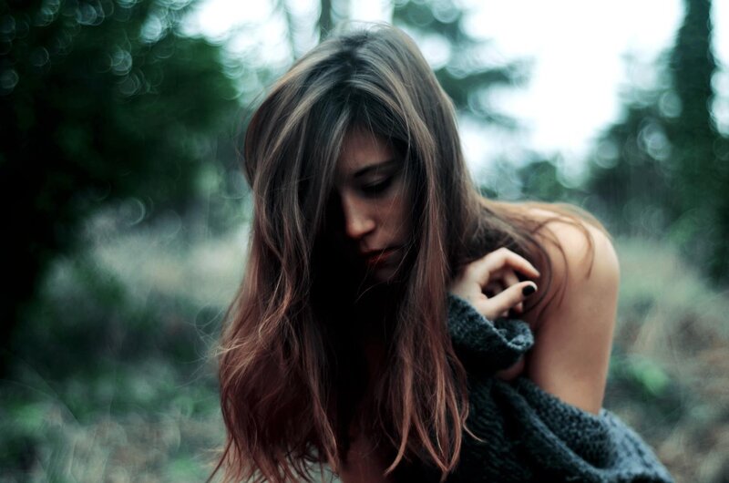 woman in forest with sweater