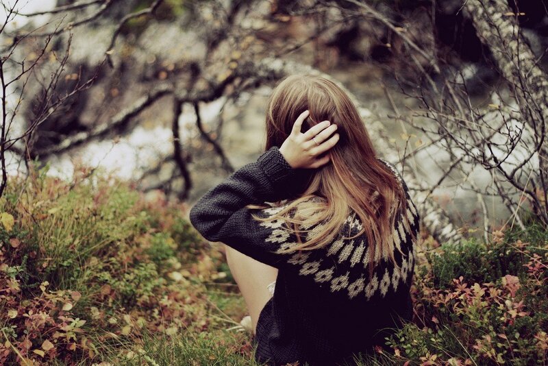 woman in forest with sweater