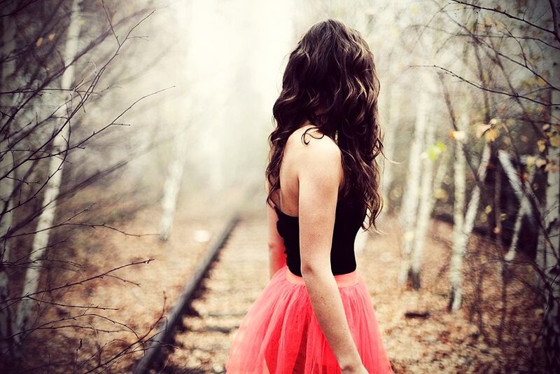 woman in forest with train tracks